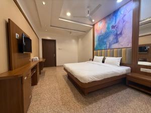 a bedroom with a bed and a large painting on the wall at Sai Srushti Residency in Kalyan