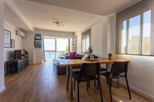 a dining room and living room with a table and chairs at Lighthouse Cullera Penthouse in Cullera