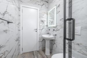 a white bathroom with a sink and a mirror at Hotel Mondo in Budva +46 photos
