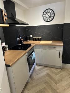 a kitchen with a counter and a clock on the wall at Towerknowe in Hawick