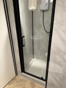 a shower with a glass door in a bathroom at Towerknowe in Hawick +4 photos
