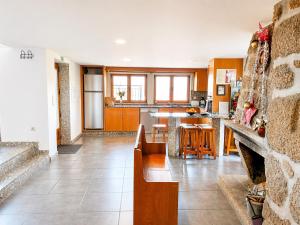 a kitchen and living room with a couch and a table at Casa da Lage - Piscina privada - Vistas rio - "Gerês" in Geres +59 photos