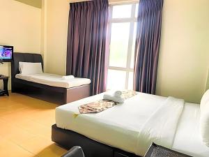 a hotel room with two beds and a window at Hotel Sayang in Kulai