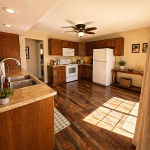 a kitchen with wooden cabinets and a white refrigerator at Buccaneer Bay #28 - Beachfront Bliss in Sunrise Beach
