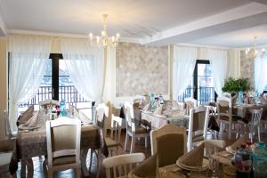uma sala de jantar com mesas e cadeiras e um lustre em Luisenthal Conac em Fundu Moldovei