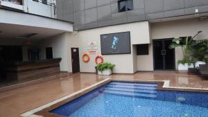 a swimming pool with a tv in a building at Limeridge Signature Hotel in Ikeja