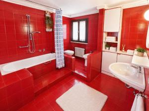 a red bathroom with a tub and a sink at La Casa del Mare in Caorle
