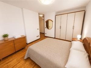 a bedroom with a bed and a dresser and a mirror at La Casa del Mare in Caorle
