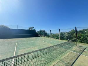 a tennis court with a net on top of it at Chakas Rock Ocean View Bliss Ballito in Ballito