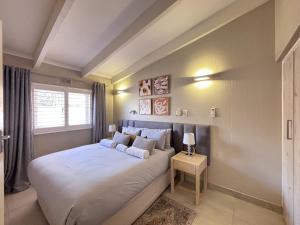 a bedroom with a large white bed with a window at Chakas Rock Ocean View Bliss Ballito in Ballito