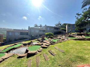 a golf course in a yard with buildings in the background at Chakas Rock Ocean View Bliss Ballito in Ballito