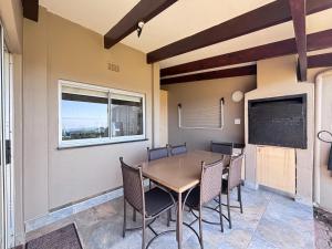 a dining room with a table and chairs and a chalkboard at Chakas Rock Ocean View Bliss Ballito in Ballito