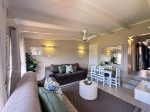 a living room with a couch and a table at Chakas Rock Ocean View Bliss Ballito in Ballito +23 photos