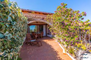 a patio with a table and chairs and flowers at Casa Corallina in Olbia