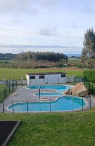 a group of three swimming pools in a park at Apartamento Jurásico in Barreiros