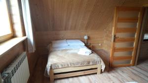 a small room with a bed in a wooden cabin at Katilux willa in Nowy Targ +43 photos