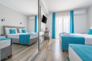 a hotel room with two beds and a mirror at Hotel Mondo in Budva