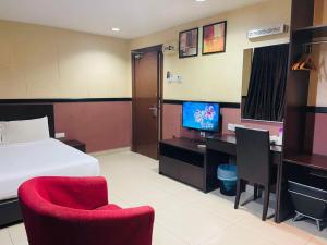 a hotel room with a bed and a desk with a computer at Hotel Sayang in Kulai +33 photos