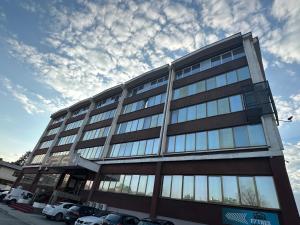 a tall building with glass windows on a street at Koncept RK in Banja Luka