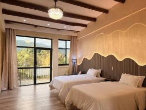 a bedroom with two beds and a large window at Java Boutique Hotel in Lushoto