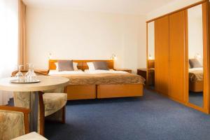 a hotel room with a bed and a table at Strandhotel Deichläufer in Butjadingen
