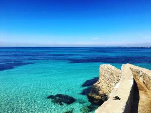 a view of the ocean with blue water and rocks at Casa Vacanze Villa Chiara in San Vito +16 photos