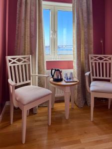 a room with two chairs and a table and a window at Hotell Nostalgi in Motala
