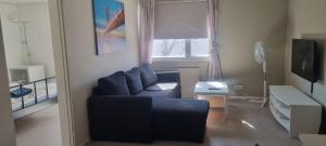 a living room with a blue couch and a window at Sackle's place in Pori