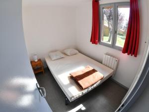 a small bedroom with a bed with a window at Camping Onlycamp l'Astrée in Bourg-Argental +6 photos