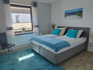 a bedroom with a bed with blue sheets and a window at Ferienwohnung mit Meerblick, 2 Schlafzi, Box- Bett, Süd- Balkon, eig, Parkplatz, Glasfaser in Dahme