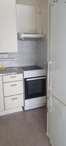 a kitchen with a white stove and a refrigerator at Sackle's place in Pori +9 photos