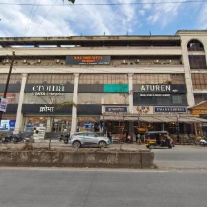 a large building with cars parked in front of it at Sai Srushti Residency in Kalyan