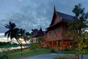 une grande maison en bois avec un arbre dans l'établissement RK Riverside Resort & Spa (Reon Kruewal), à Ban Khlong Krang
