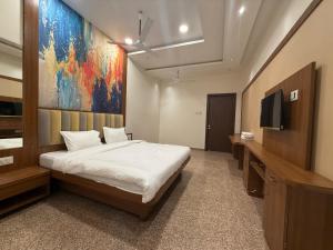 a bedroom with a bed and a tv in it at Sai Srushti Residency in Kalyan