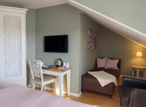a room with a bed and a desk with a chair at Hotell Nostalgi in Motala