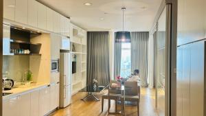 a kitchen and dining room with a table and a man sitting at a table at Platinum Astern SUITES by KLCC in Kuala Lumpur