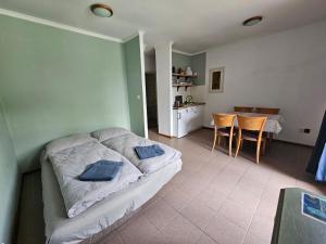 a bedroom with a bed and a table and a kitchen at Dömös Danu Kemping in Dömös