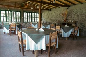 a dining room with tables and chairs in a building at Finca La Media Luna in San Agustín de Valle Fértil