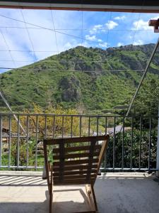 a bench on a balcony with a view of a mountain at Guest House Ucha in Mtskheta