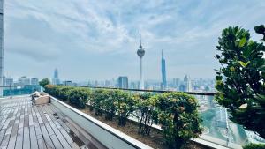 a man sitting on a balcony with a view of a city at Platinum Astern SUITES by KLCC in Kuala Lumpur
