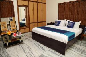 a bedroom with a large bed with blue and white pillows at Sudha Grand Guestinn in Nellore