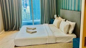 a hotel room with a bed with two books on it at Platinum Astern SUITES by KLCC in Kuala Lumpur +123 photos
