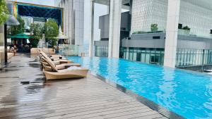 a swimming pool with lounge chairs in a building at Platinum Astern SUITES by KLCC in Kuala Lumpur