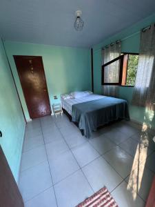 a bedroom with a bed in the corner of a room at Chalé da jessica in Paraty