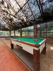 a pool table in a room with a ceiling at Hotel Pousada Cata Branca in Itabirito