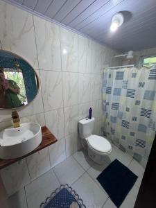 a bathroom with a toilet and a sink and a mirror at Chalé da jessica in Paraty