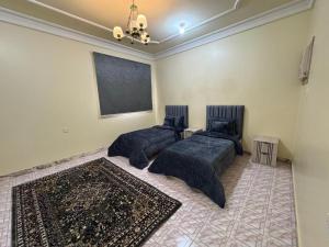 a bedroom with two beds and a chalkboard on the wall at ANA Apartment in Hail