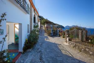 a narrow street with a building and the ocean at Estate4home - Suites Margar in Massa Lubrense
