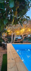 two pictures of a wooden bench under a tree with lights at Can Sais in Pals
