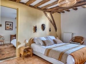a bedroom with a large bed and a mirror at Le Petit Serrant - maison d'hôtes d'exception in Bouchemaine